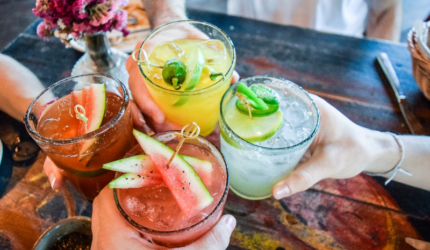 ladies hands holding many margaritas