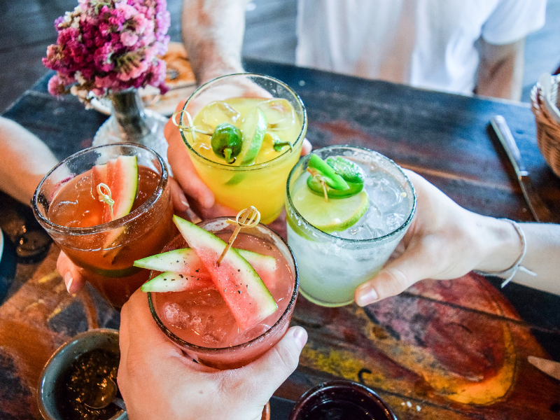 ladies hands holding many margaritas